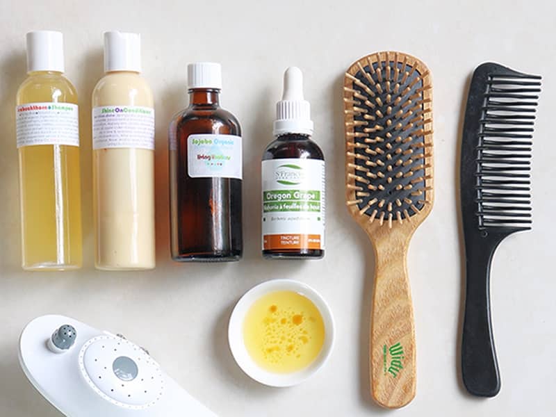 A scalp treatment for acne prone skin using oregon grape extract, jojoba oil, Widu wooden brush, and haircare products from Living Libations.